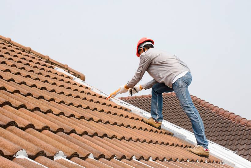 Professional roofer working on slate roof