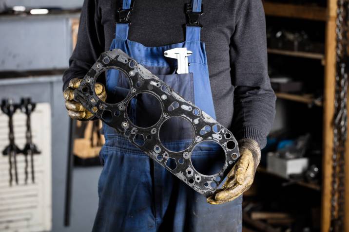 a mechanic holding a head gasket
